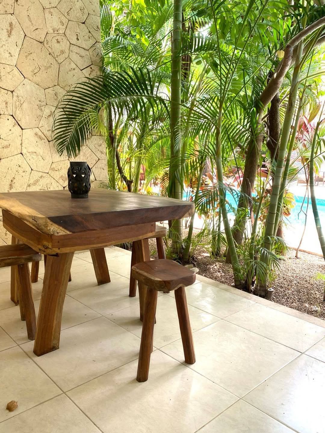 Mesa de madera y bancos en un comedor exterior entre plantas