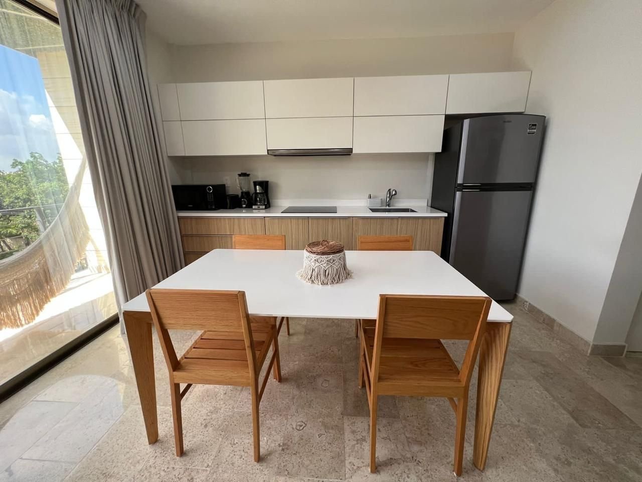 Comedor junto al ventanal, con la cocina al fondo