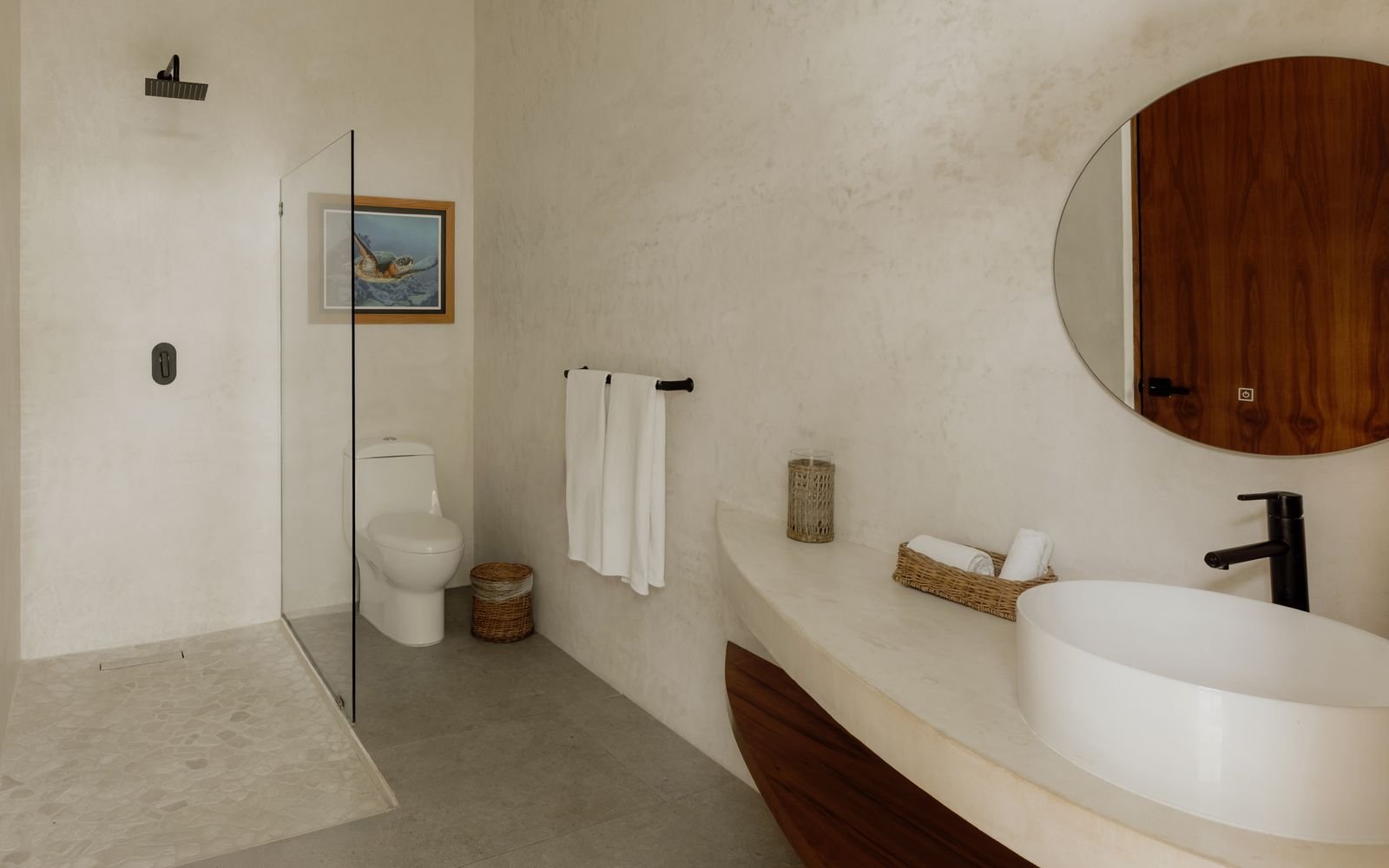 Baño con regadera, inodoro y lavabo blanco sobre cubierta curva
