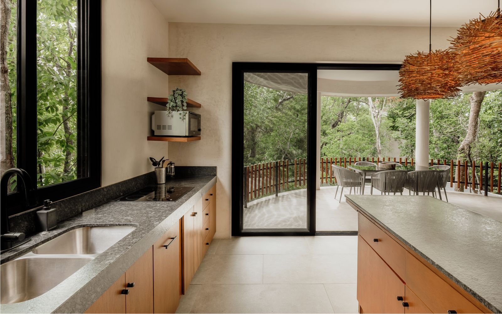Cocina con cubierta de piedra, tarja doble y salida a una terraza