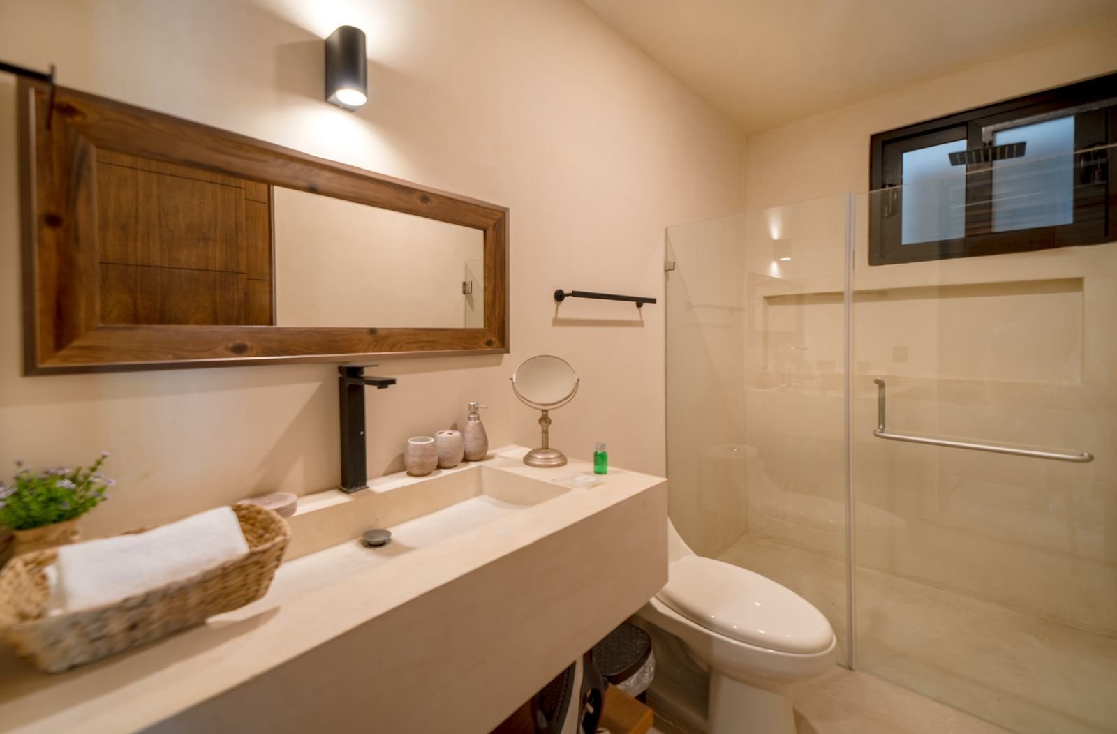 Baño con lavabo, inodoro y regadera con cancel de cristal