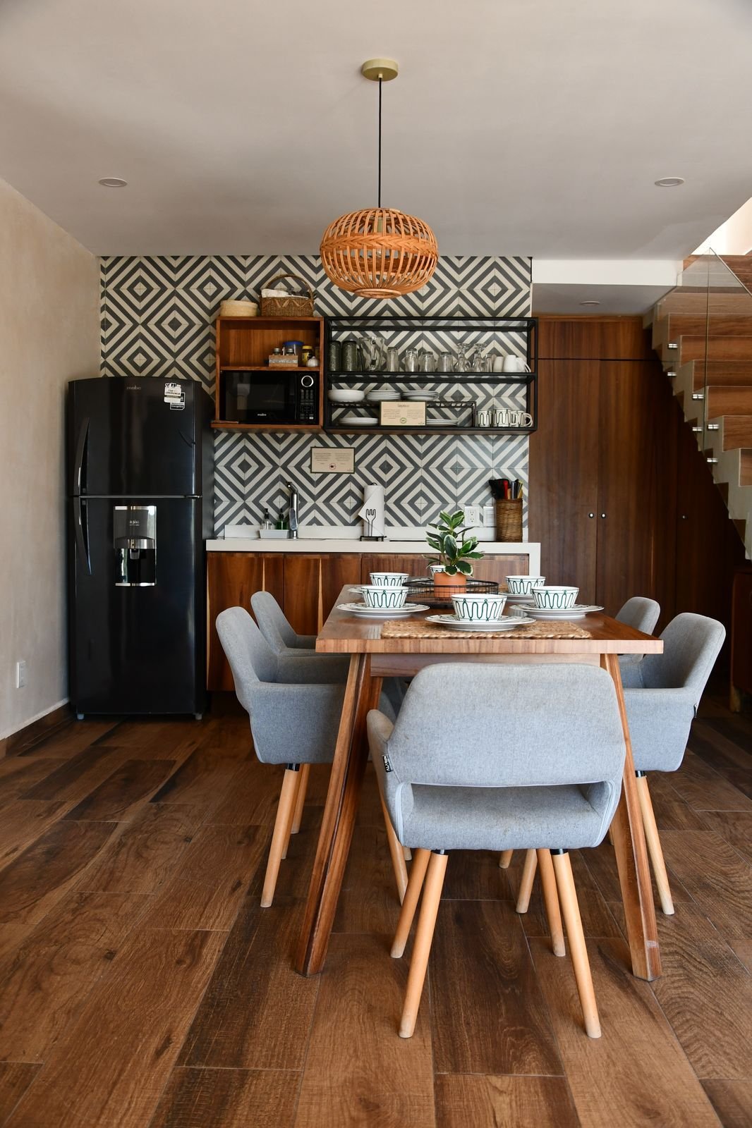 Cocina con refrigerador, cubierta y una mesa con sillas