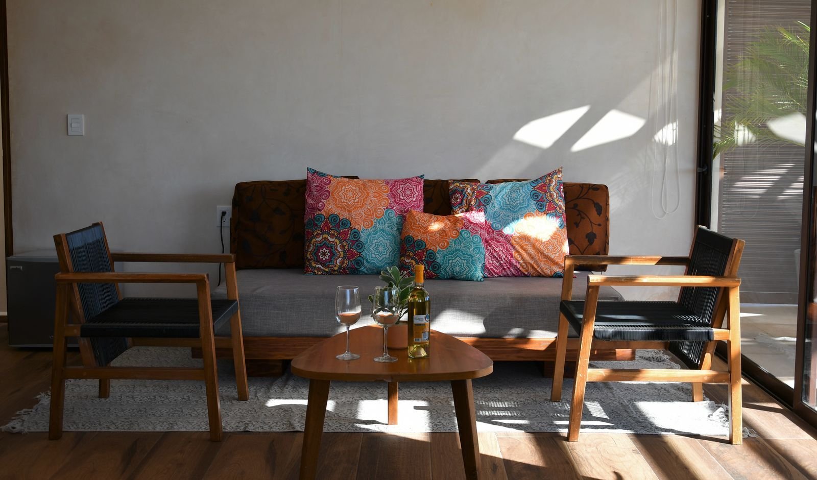 Sala con sofá de colores, dos sillones y una mesa baja