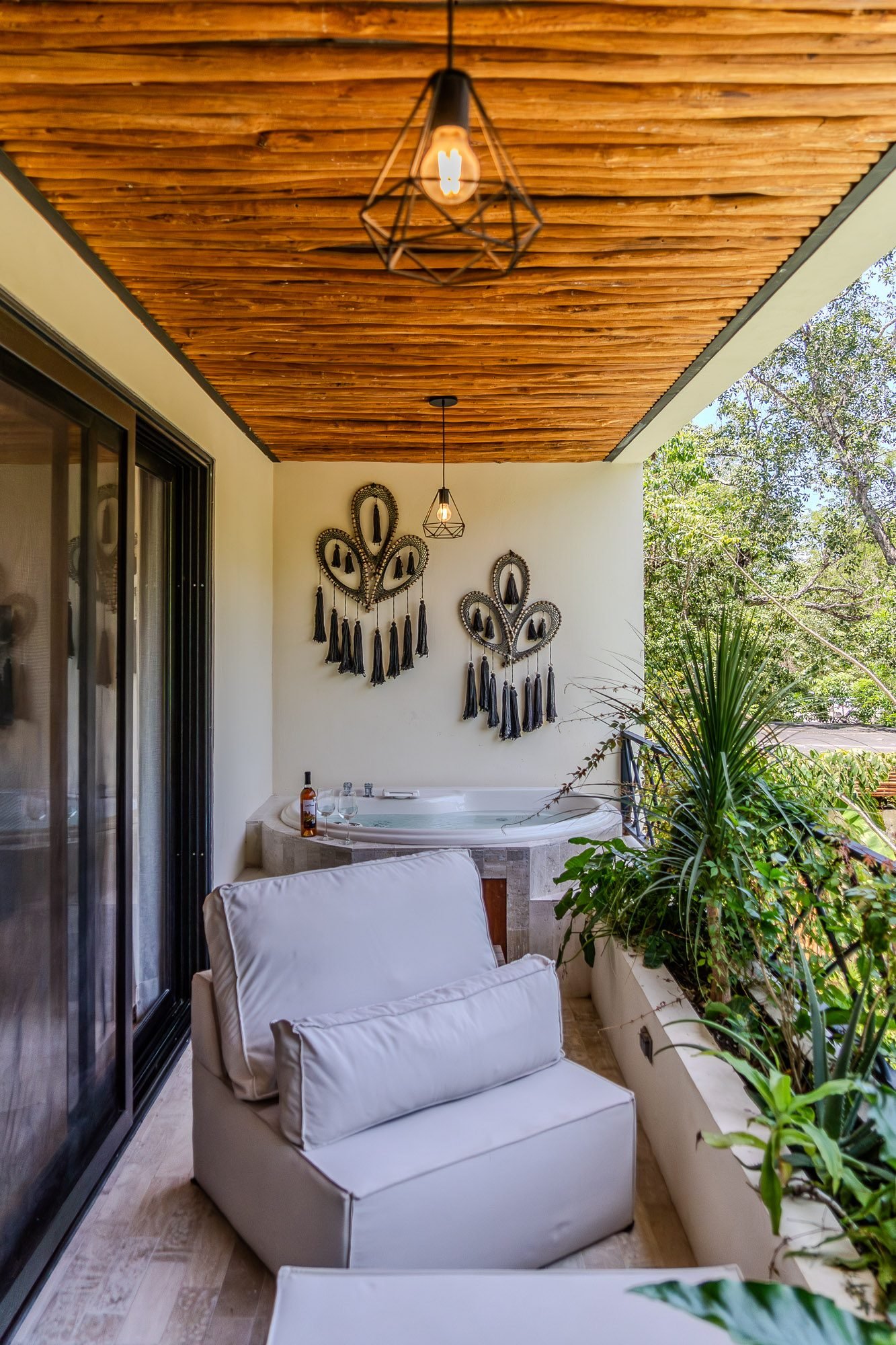 Terraza con jacuzzi, sillón y decoración artesanal con techo de madera